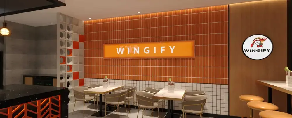 Inside the Wingify dining room — orange tile wall with the Wingify sign over the tables